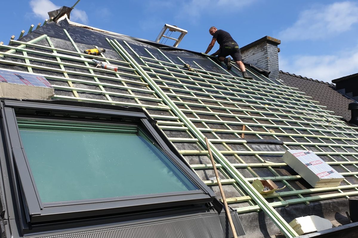 Werner werkt aan een hellend dak in opbouw met dakraam en lattenwerk